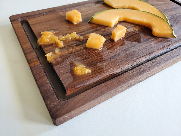 Sliced cantaloupe on a wooden cutting board
